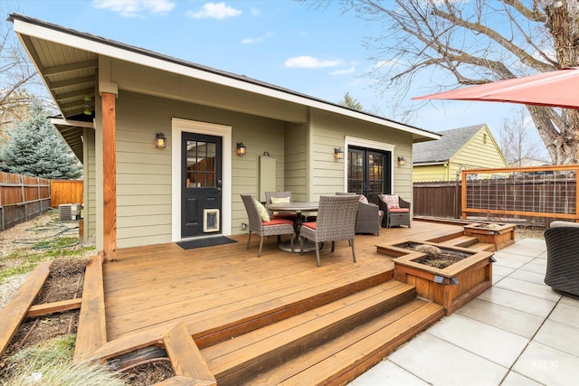 wooden deck featuring an outdoor living space with a fire pit, central air condition unit, outdoor dining area, and fence