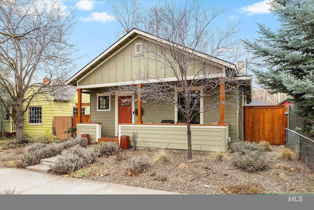 view of front of house featuring fence and covered porch