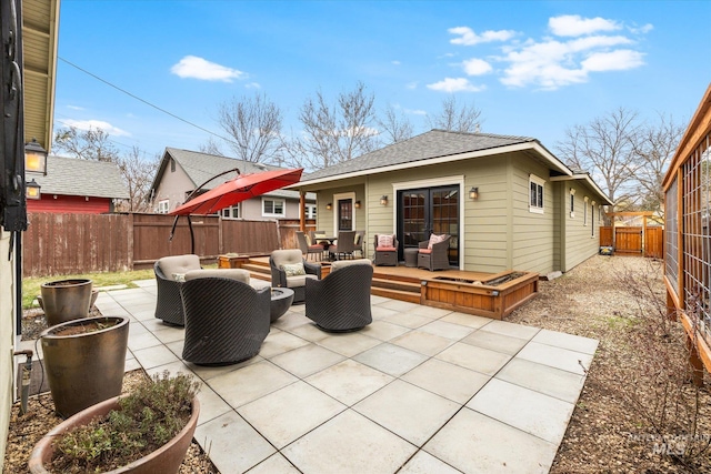 rear view of property featuring a fenced backyard, an outdoor hangout area, a patio, and roof with shingles