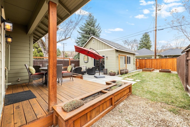 wooden deck with a yard, an outdoor living space with a fire pit, and a fenced backyard