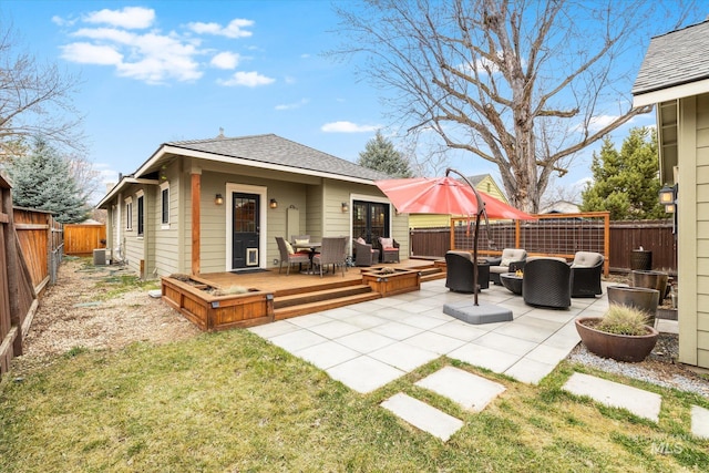 rear view of house featuring a patio, a fenced backyard, central AC, a shingled roof, and an outdoor hangout area