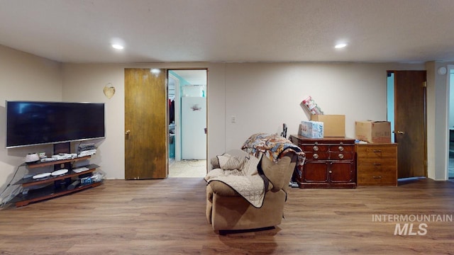 living area with light wood-style flooring and recessed lighting