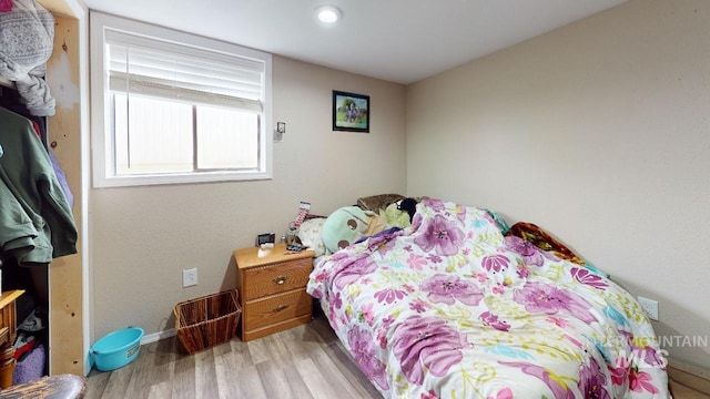 bedroom with light wood-style flooring and baseboards