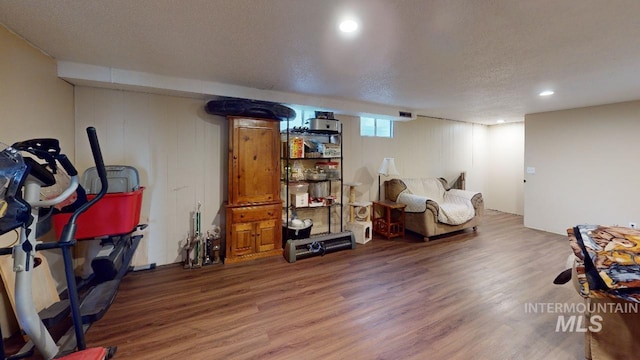 below grade area featuring a textured ceiling, wood finished floors, visible vents, and recessed lighting