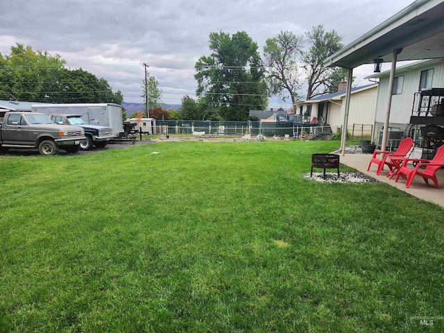 view of yard featuring fence and a fire pit