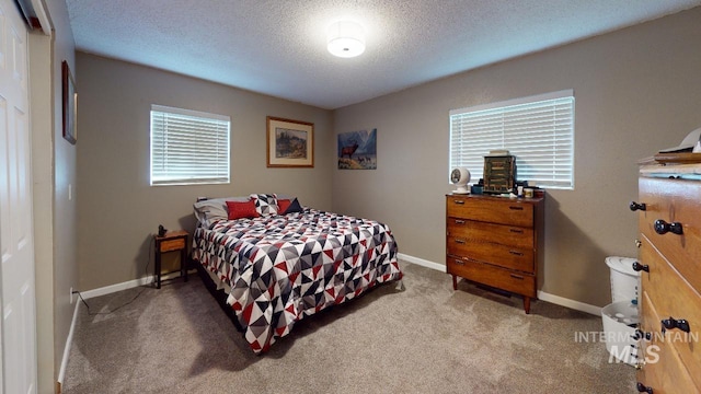 bedroom with a textured ceiling, carpet, and baseboards