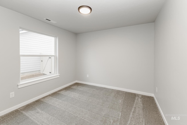 carpeted empty room featuring visible vents and baseboards