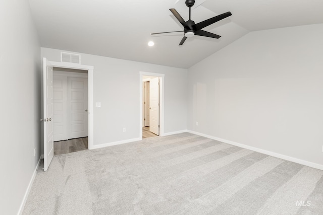 unfurnished bedroom featuring a ceiling fan, baseboards, visible vents, carpet floors, and lofted ceiling