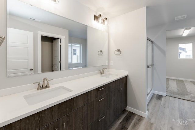 bathroom featuring double vanity, visible vents, a stall shower, and a sink