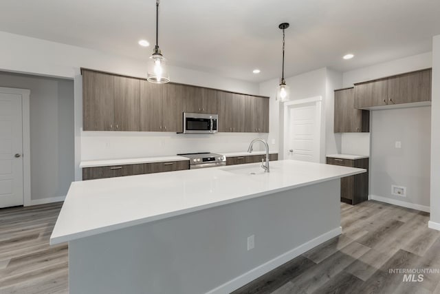 kitchen with a sink, light countertops, modern cabinets, and stainless steel appliances