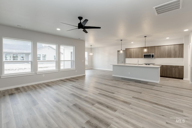 unfurnished living room featuring recessed lighting, baseboards, visible vents, and light wood-type flooring