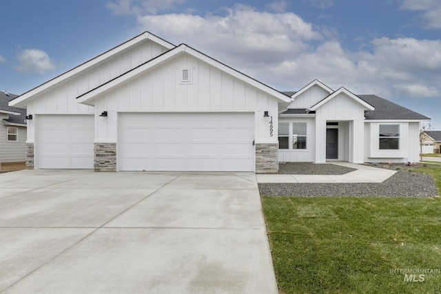 modern farmhouse style home with board and batten siding, concrete driveway, roof with shingles, stone siding, and an attached garage