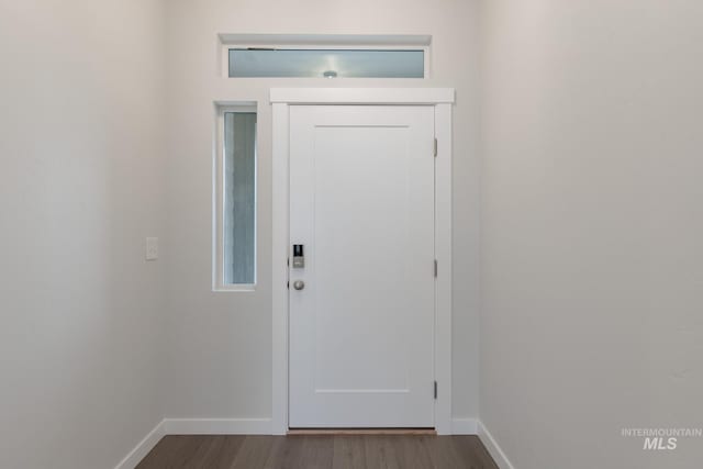 doorway with baseboards and dark wood finished floors