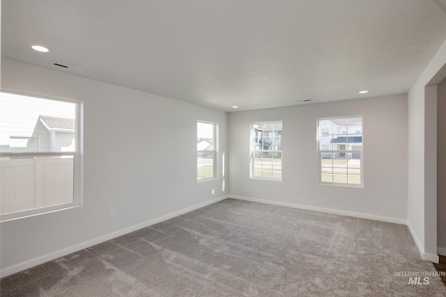 carpeted empty room with recessed lighting, visible vents, and baseboards