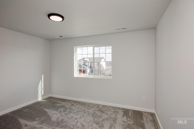 carpeted spare room with visible vents and baseboards