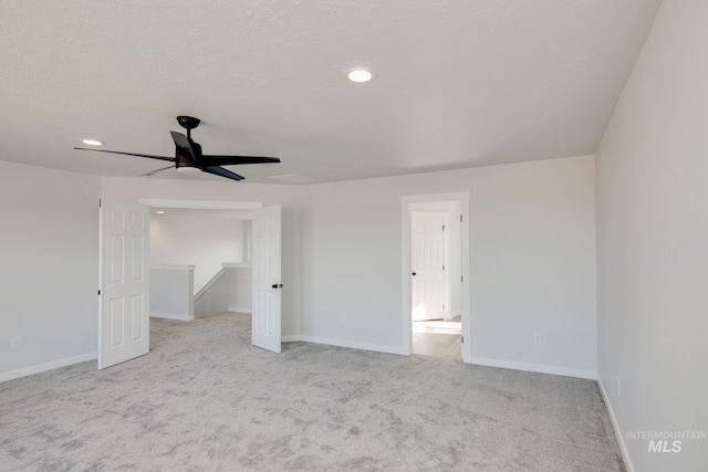 unfurnished bedroom with light carpet, baseboards, a textured ceiling, and recessed lighting