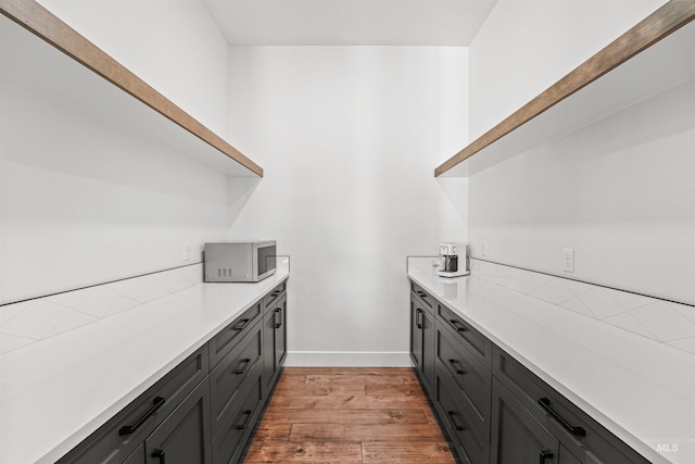 kitchen featuring light countertops, baseboards, light wood-type flooring, and open shelves