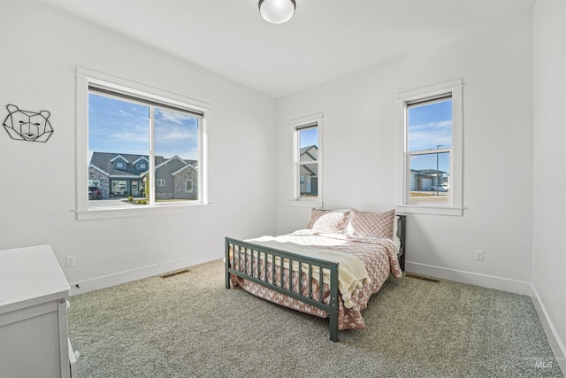 carpeted bedroom with visible vents and baseboards