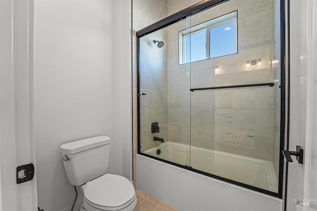 bathroom with tile patterned floors, toilet, and combined bath / shower with glass door