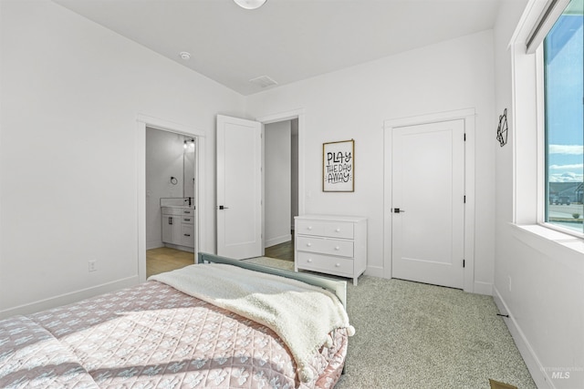 bedroom with multiple windows, baseboards, and light carpet