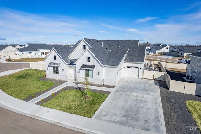 view of front facade featuring a residential view, board and batten siding, driveway, and fence