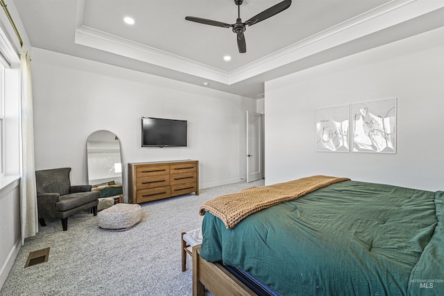 carpeted bedroom featuring visible vents, crown molding, a raised ceiling, and baseboards