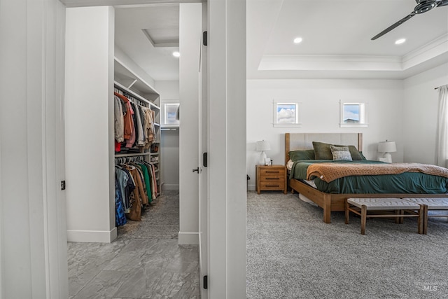 bedroom featuring multiple windows, a raised ceiling, attic access, and a spacious closet