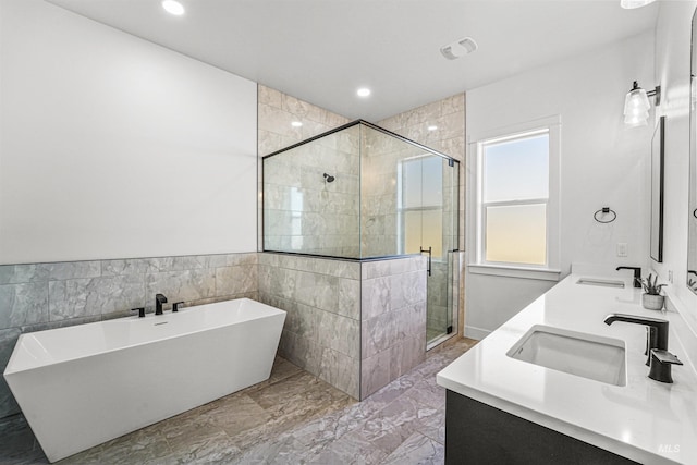 full bathroom with a sink, a soaking tub, double vanity, and a shower stall