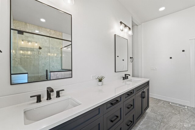 full bath with a sink, visible vents, marble finish floor, and a shower stall