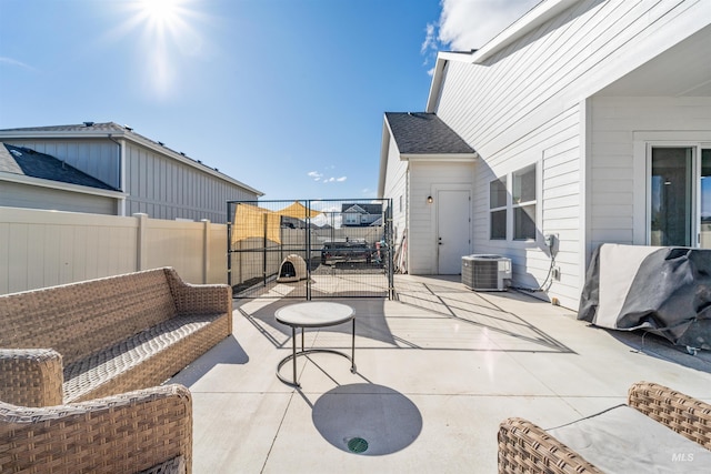 view of patio / terrace featuring central air condition unit and fence