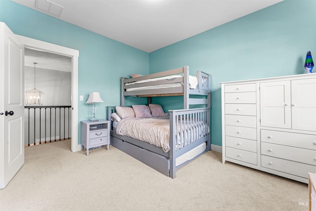 bedroom with light colored carpet and a notable chandelier