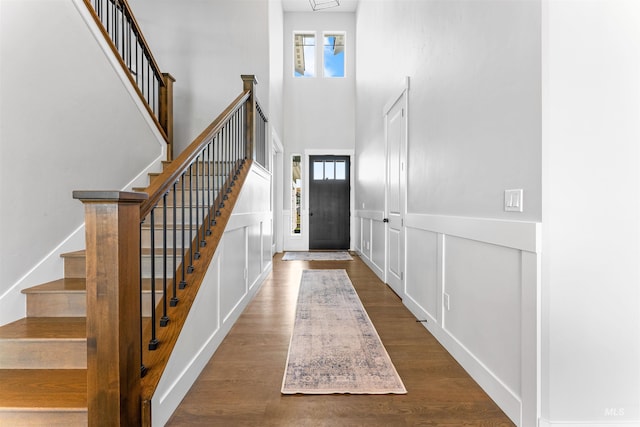 foyer featuring hardwood / wood-style flooring, a wealth of natural light, and a towering ceiling