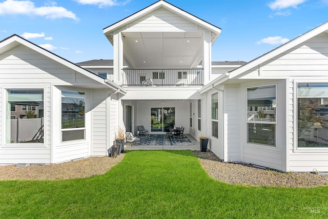 back of house featuring a yard, a patio area, and a balcony