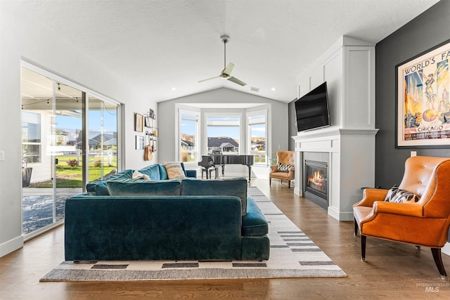 living room featuring hardwood / wood-style floors, lofted ceiling, and a textured ceiling