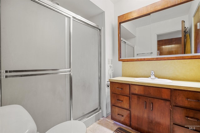 full bathroom featuring vanity, toilet, and a shower stall