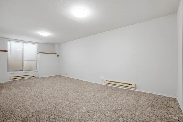 carpeted spare room with a baseboard radiator and baseboards