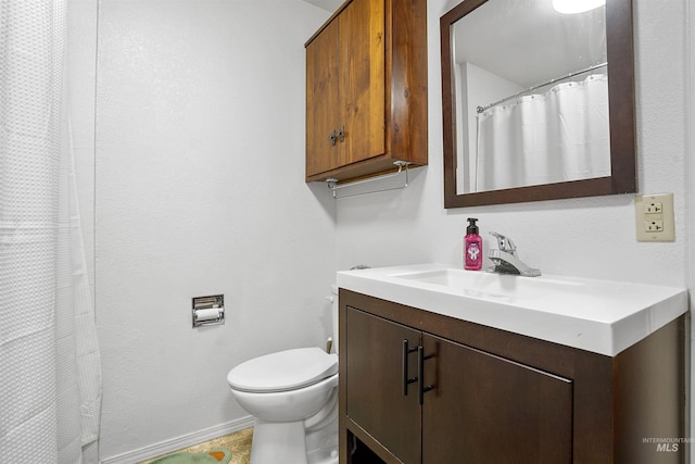 full bath featuring vanity, toilet, and baseboards