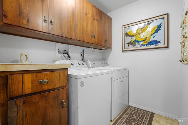 laundry area featuring baseboards, washer and dryer, and cabinet space