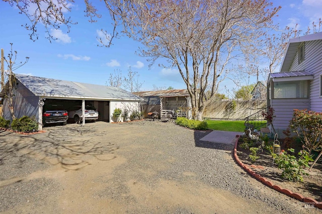 view of yard featuring fence and a carport