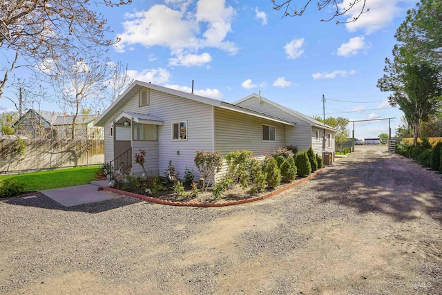 view of property exterior with fence and entry steps