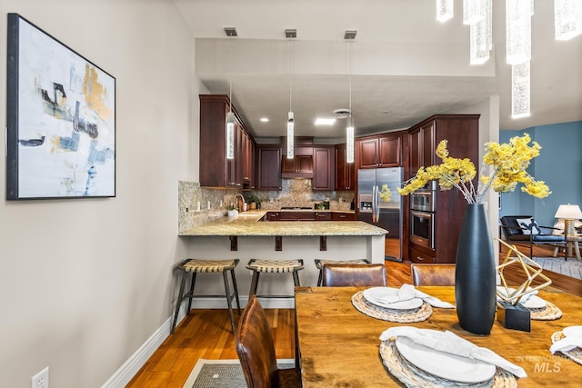 dining area featuring baseboards and light wood-type flooring