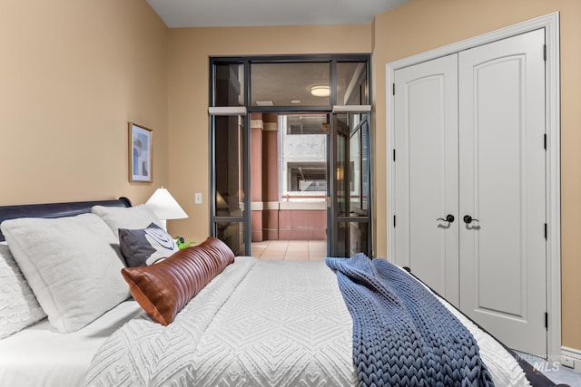 bedroom with tile patterned floors and a closet