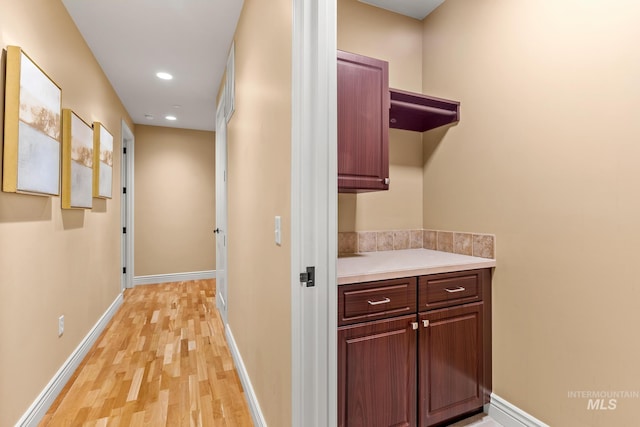 corridor featuring recessed lighting, baseboards, and light wood-type flooring