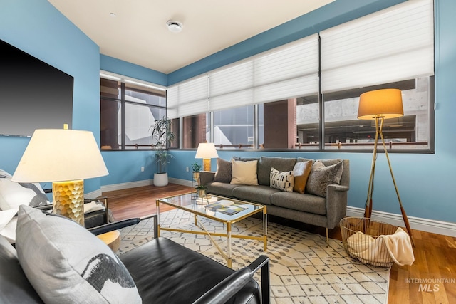 living area with baseboards and wood finished floors