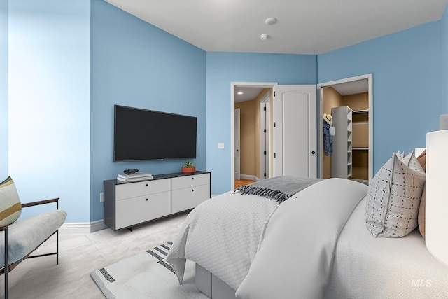 bedroom featuring baseboards and a spacious closet