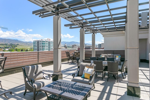 view of patio with outdoor dining space, a mountain view, and a pergola