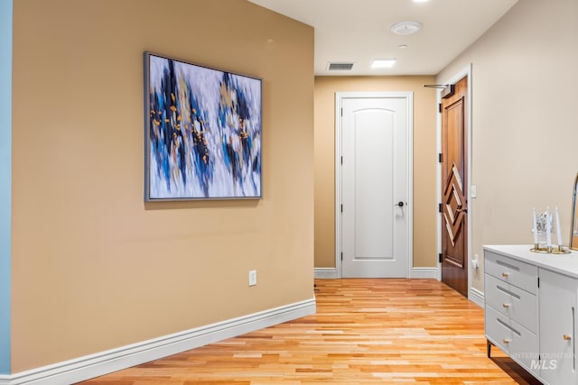 interior space with baseboards, visible vents, and light wood-type flooring