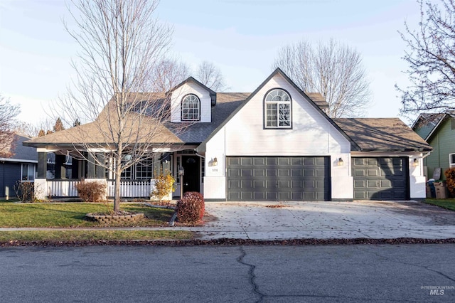 view of front of home featuring a front yard, a porch, and a garage