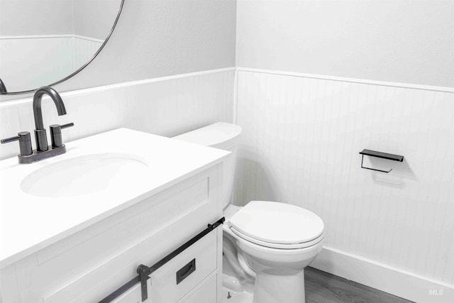 bathroom with vanity, toilet, and wood-type flooring