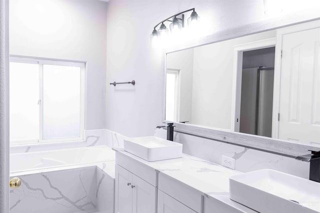 bathroom featuring vanity and tiled bath